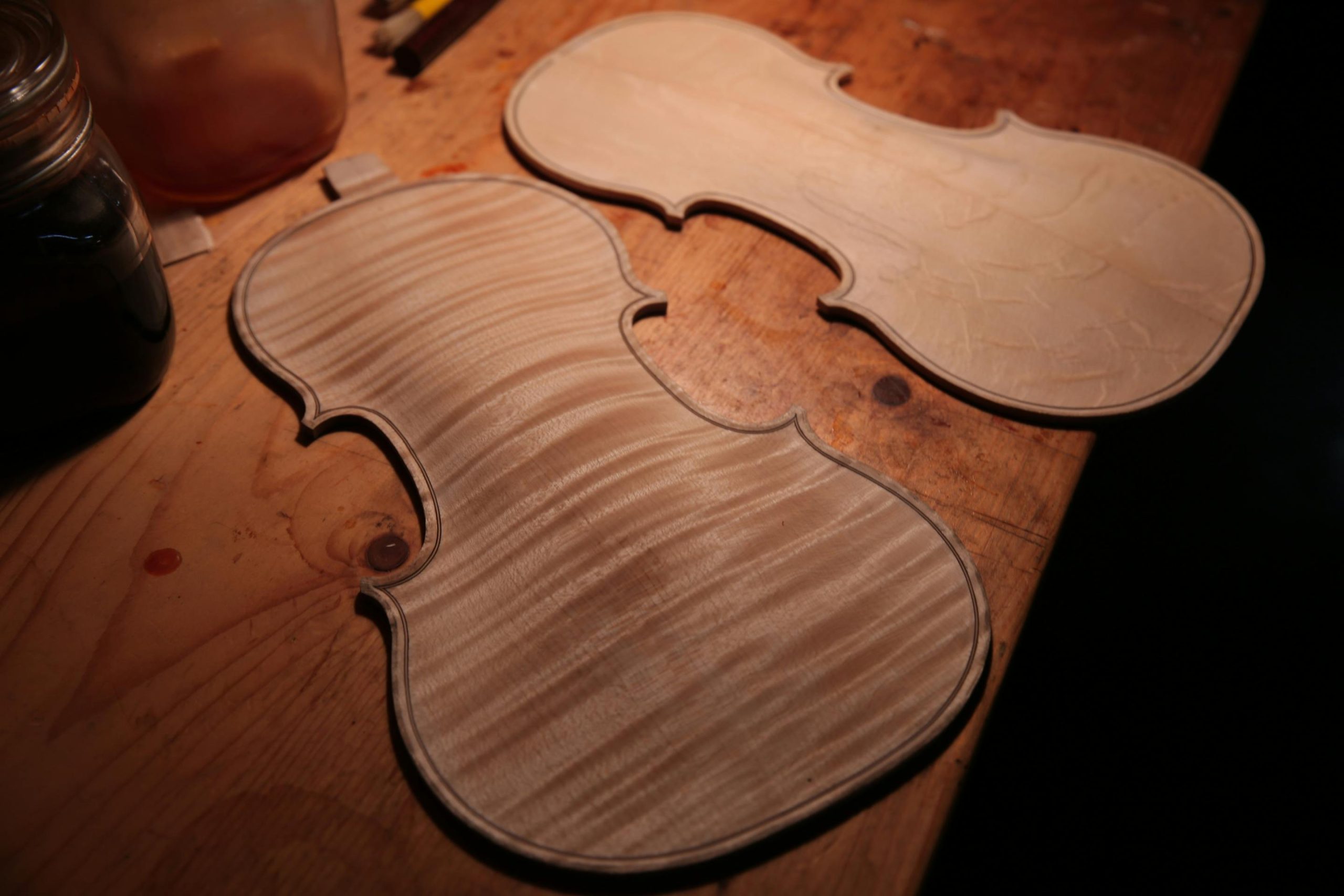Violin plates being shaped on a luthier's workbench